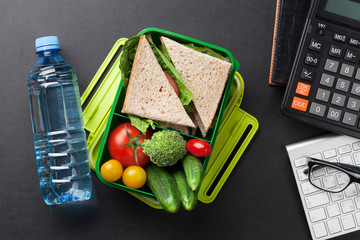 Office desk with supplies and lunch box