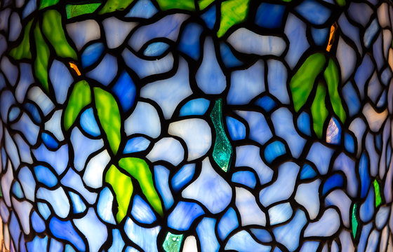 Wisteria pattern illuminated stained glass close up detail.