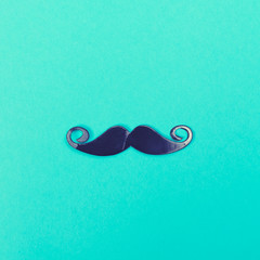 Paper party mustache accessory on a bright blue background