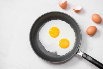 Top view of traditional healthy easy quick breakfast meal made of fried eggs served on a frying pan.