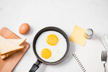Top view of traditional healthy easy quick breakfast meal made of fried eggs served on a frying pan.
