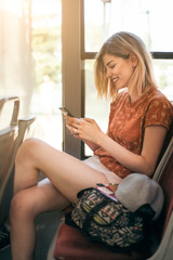 Young teenage girl using her cell phone in public transportation 