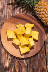Tropical fruit concept. Cutted pineapple on the old wooden background.