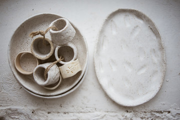 Top view on two grog clay plates with beautiful rustic napkin rings on white background