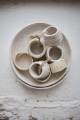 Top view on grog clay plate with beautiful rustic napkin rings on white background