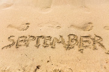 Inscription on wet sand september
beach.