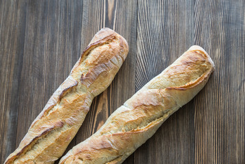 Two baguettes on the wooden background