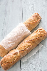 Two baguettes on the wooden background
