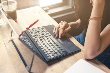 woman working on laptop,business office desk,using laptop computer technology on table for searching and planing successful concept,vintage tone and day light flare.