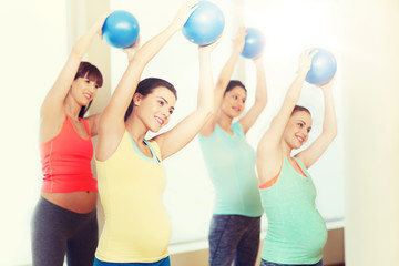 happy pregnant women exercising with ball in gym