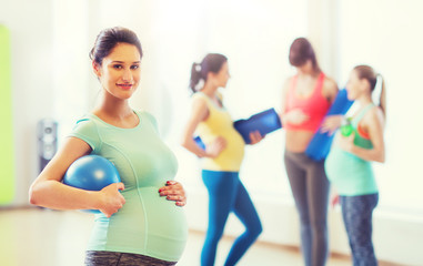 Fototapeta na wymiar happy pregnant woman with ball in gym