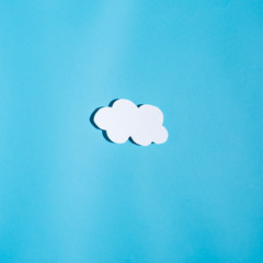 Paper cloud with hard shadow on a blue background