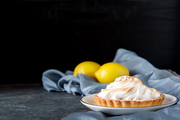 French dessert. Tartlet with lemon. Dark background.