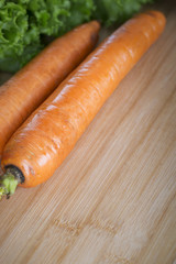 Fresh carrot on a wooden board in kitchen,closeup.