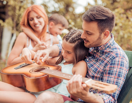 Family having fun,playing the guitar