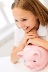 happy girl with piggy bank at home