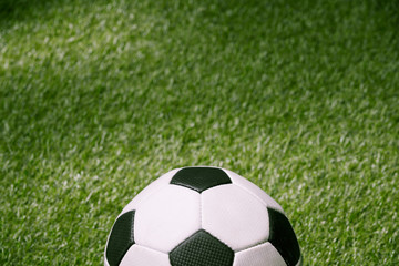 close up of classic soccer ball on green football pitch