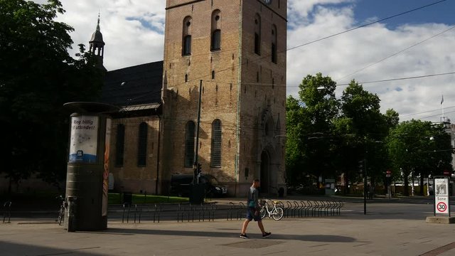 Tilt down from the Oslo Cathedral to a tram passing by