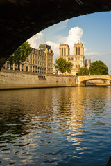 Notre-Dame cathedral in Paris and the Police headquarters under a warm sunlight with the river Seine and the wharf in the foreground.