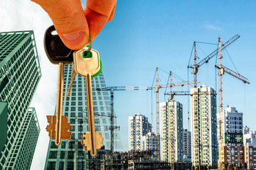 The keys on the background of the construction of new modern buildings . The concept of the...
