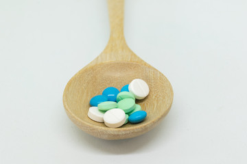 Fototapeta na wymiar Many medicines in wooden spoon on white background. Concept healthy careful.