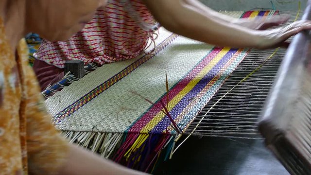 Two ladies weaving a matras in Hoi An Vietnam