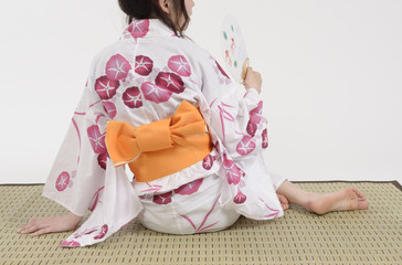 畳に座る浴衣姿の女性