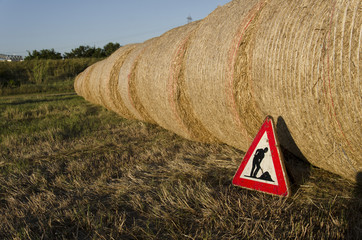 Under construction sign with straw bales