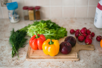 On the kitchen table lying fresh vegetables for salad