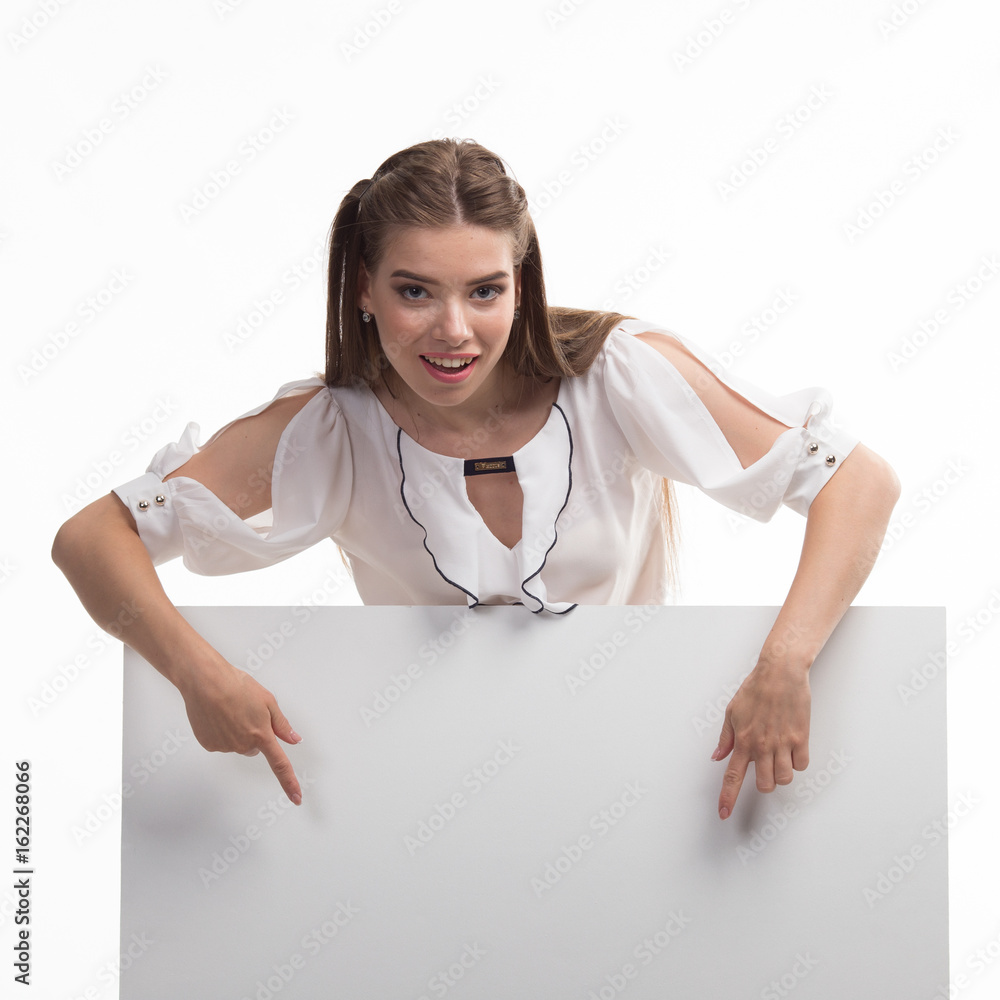 Wall mural young happy woman portrait of a confident businesswoman showing presentation, pointing placard gray 