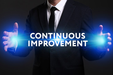 Business, Technology, Internet and network concept. Young businessman working on a virtual screen of the future and sees the inscription: Continuous improvement