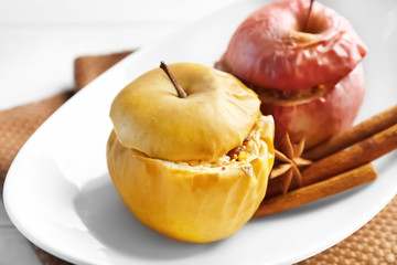Plate with tasty baked apples and cinnamon on table, closeup