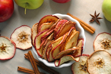 Composition with apple chips and cinnamon on table, closeup