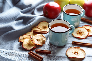 Composition with apple juice, chips and cinnamon sticks on wooden table