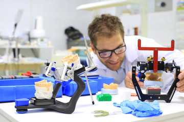 Dental technician checks his work in the lab