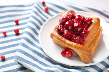 Plate with puff and cherry on striped napkin