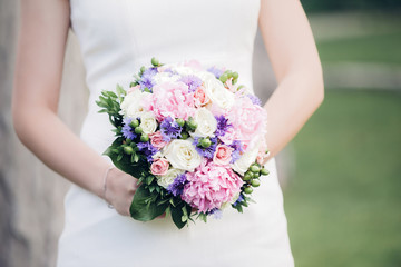 Obraz na płótnie Canvas bride's hands hold beautiful wedding bouquet