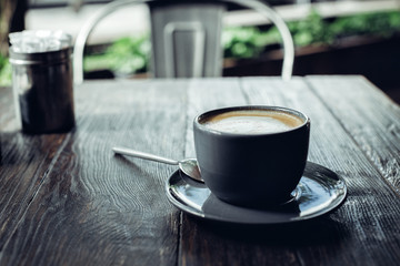 cup of fragrant coffee with foam on dark wooden table
