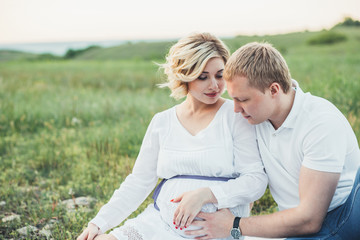 beautiful pregnant girl and her husband in the nature