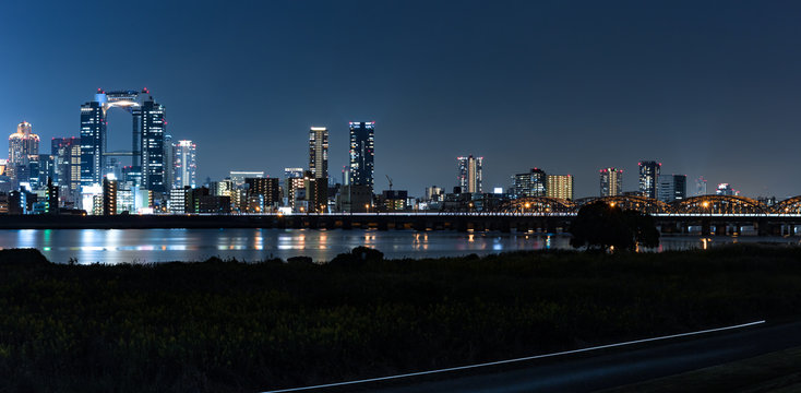 Night cityscape panorama of Osaka city center captured from the Yodogawa ward across the Yoda river