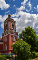 Fototapeta na wymiar Russian church bell tower on a cloudy sky background