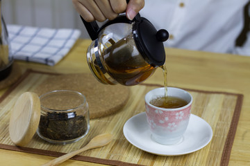 Man Pouring tea in house.
