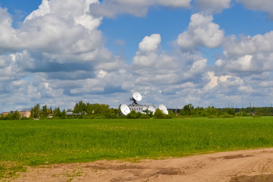 Several large satellite communication antennas in a field against a blue sky. Space Communication Center
