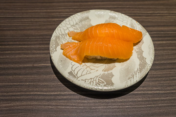 Fresh Japanese Salmon Sushi in white dish on wood table