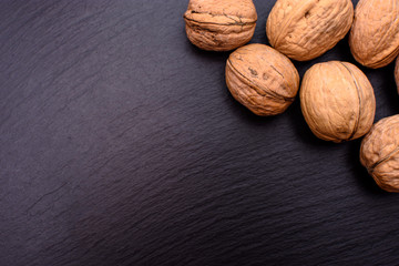 Walnut on black stone board background, frame space for text