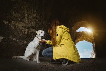 Labrador Retriever Hund Welpe und junge Frau geben sich ein High Five beim Wandern in einer Höhle 