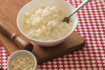 Brazilian dessert sweet canjica of white corn with pacoca sweet in bowl and towel. Festa Junina Party Brazilian Culture Concept Image.