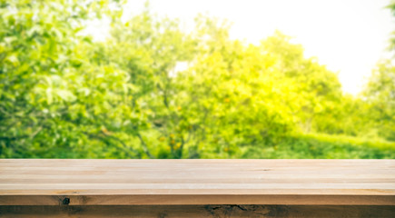 Fototapeta premium Wood table top with blur of orange garden in the morning.For montage product display or key visual layout