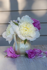 bouquet of white and purple peonies in vase with shadow