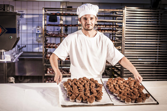 Confectioner presenting baking trays with pastries